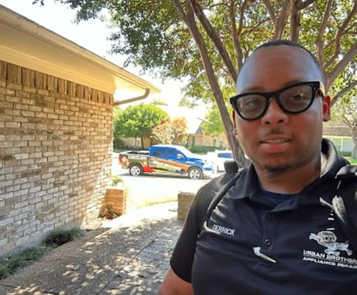 Urban Brothers technician outside home with service truck in background