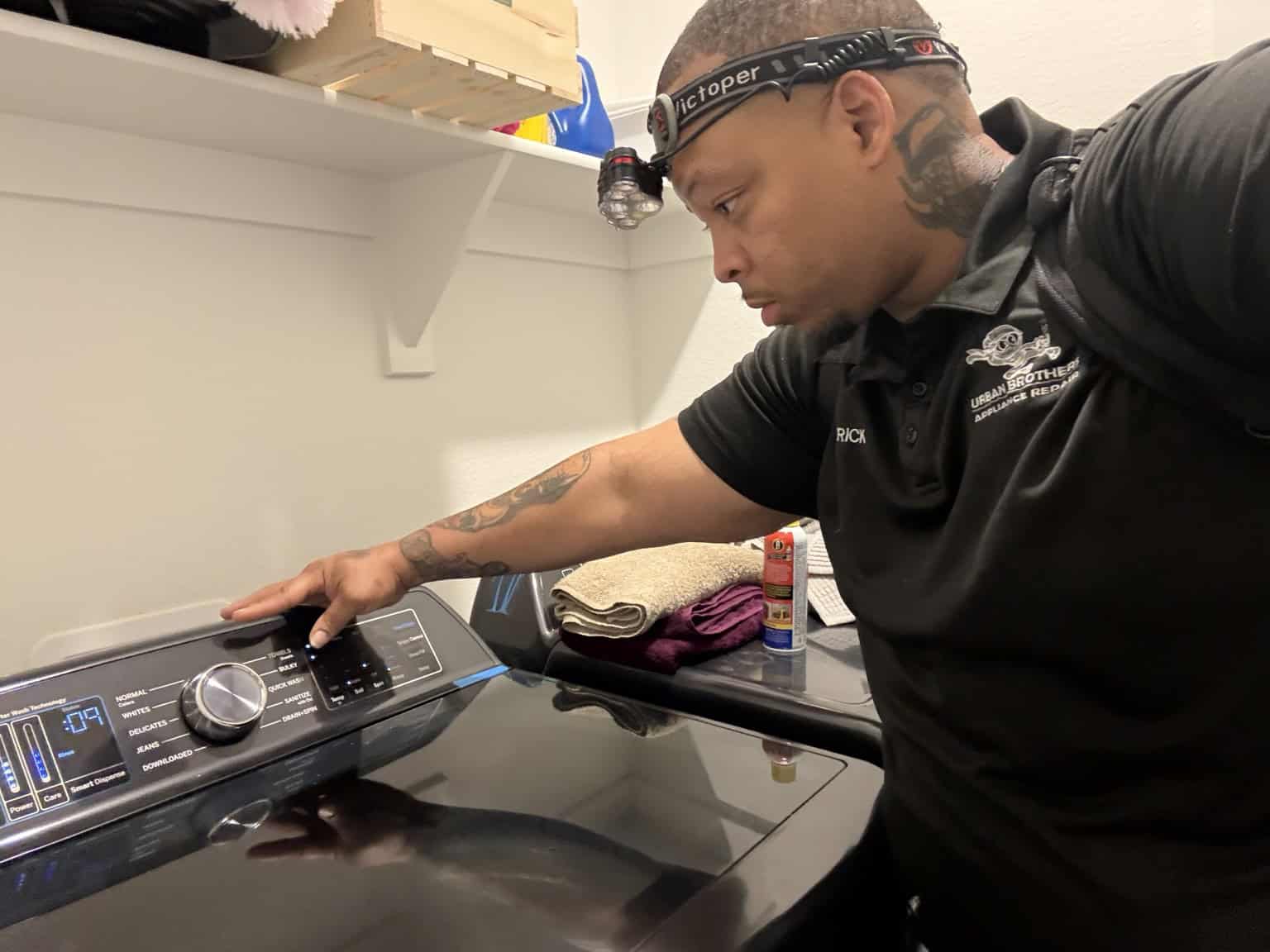 Urban Brothers appliance technician checking a top-load washing machine